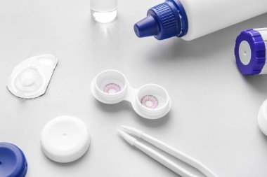 Çözüm şişesi, cımbız ve kontak lensli konteynır.