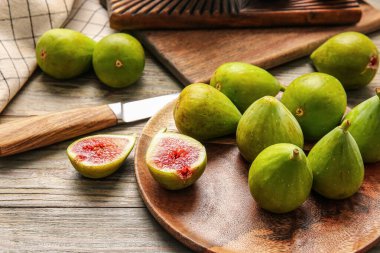 Ahşap zemin üzerinde taze yeşil incir tabağı