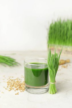 Açık arkaplanda taze buğday çimi suyu.