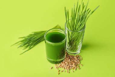 Taze buğday çimi suyu ve renk zemininde tohum.