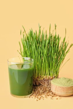 Taze buğday çimi suyu ve arkaplanda toz.