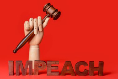 Yargıç tokmak ve IMPEACH kelime ile ahşap el renk arkaplan