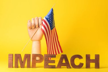 Tahta el, ABD bayrağı ve IMPEACH sözcüğü ile renk arkaplanı