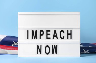 Renk arkaplanında IMPEACH Now ve USA bayrağı olan tahta