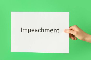 Renk arkaplan üzerinde IMPEACHMENT metin ile el ele kağıt