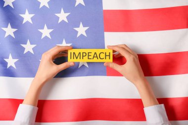 ABD bayrağına karşı IMPEACH yazılı kağıt tutan eller