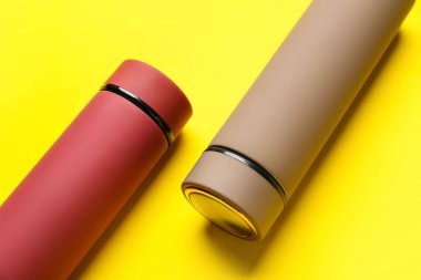 Renk arkaplanındaki modern termoslar