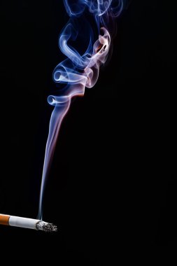 Esmer arka planda dumanlı sigara.