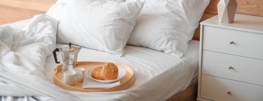 Yatakta lezzetli bir kahvaltı tepsisi.