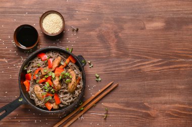 Lezzetli soba şehriyeli tava ve ahşap arka planda et.