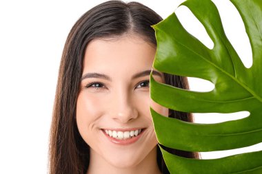 Beyaz arka planda tropikal yaprağı olan güzel genç bir kadın.