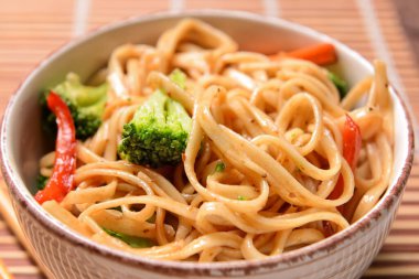 Lezzetli şehriyeli kase ve bambu hasırlı sebze.