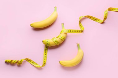 Olgun muzlar ve renkli arka planda mezuralar. Kilo verme konsepti