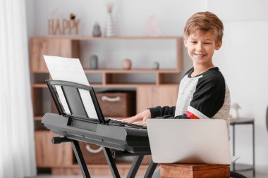 Küçük çocuk evde müzik dersleri alıyor.