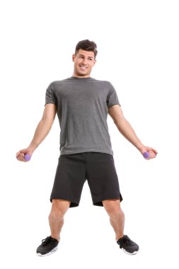 Beyaz arka planda dambılları olan komik genç adam eğitimi.