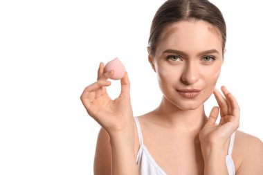 Güzel bir genç kadın beyaz arka plana makyaj yapıyor.