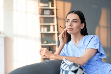 Evde sigara içen genç bir kadın.