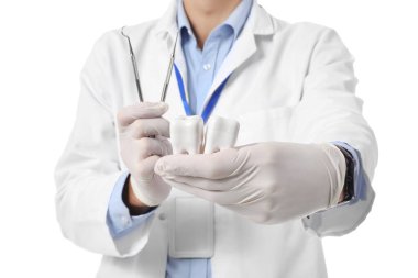 Beyaz arka planda plastik dişleri olan erkek dişçi, yakın plan.