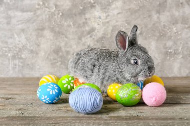 Tatlı tavşan ve Paskalya yumurtaları gri arka planda.