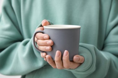 Bir fincan sıcak çay içen kadın, yakın plan.