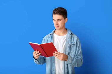 Genç adam renk arkaplanı kitabı okuyor