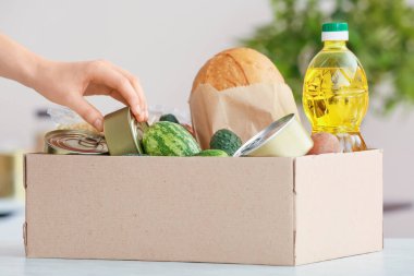 Mutfaktaki farklı ürünlerle dolu el ve boks.