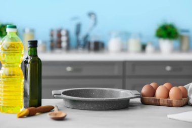 Modern mutfaktaki masada yumurta, yağ ve fırın örtüsü.