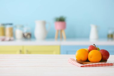 Modern mutfaktaki masada portakal ve elma tabağı.