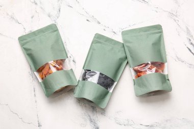 Kurumuş kayısı ve açık arkaplanda kuru erik dolu çantalar.