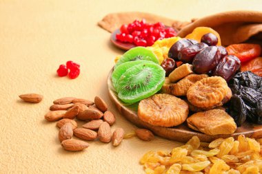 Arka planda farklı kurutulmuş meyve ve fındıklı tabak