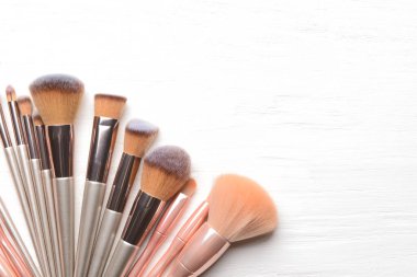 Beyaz ahşap arka planda makyaj fırçaları