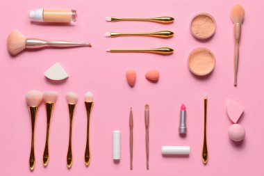 Renkli arka planda makyaj fırçaları, süngerler ve dekoratif kozmetik setleri