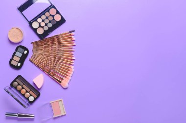 Renkli arka planda makyaj fırçaları ve dekoratif kozmetik setleri