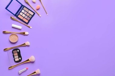 Renkli arka planda makyaj fırçaları ve dekoratif kozmetik setleri