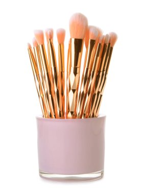 Beyaz arkaplanda makyaj fırçası seti olan tutucu