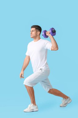 Renkli arka planda dambıl olan sportif genç adam eğitimi.