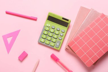 Renk arkaplanı üzerine modern hesap makinesi ve kırtasiye