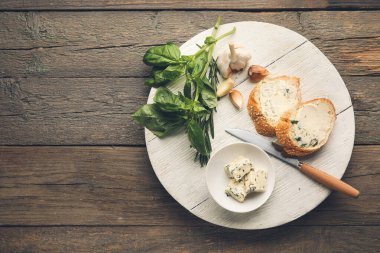 Tahta zeminde sarımsaklı tereyağlı taze ekmek dilimleri.