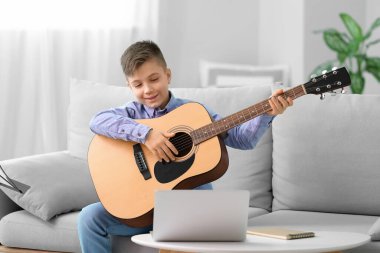 Küçük çocuk evde müzik dersleri alıyor.