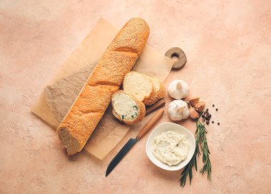 Taze ekmek, sarımsaklı tereyağı ve arka planda bulunan malzemeler.