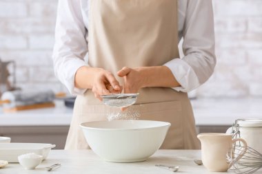 Kadın mutfaktaki masada para kazanıyor.