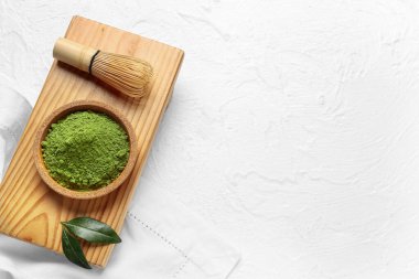 Pudralanmış kibrit çayı ve açık arkaplanda chasen ile kase