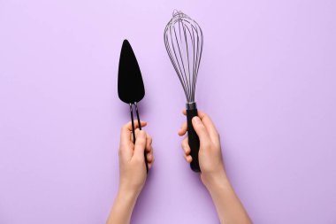 Renk arkaplanında çırpı ve pasta spatulası olan kadın elleri