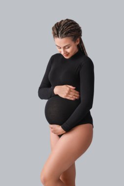 Gri arka planda güzel hamile kadın