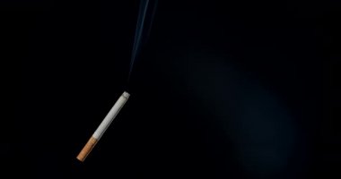 Esmer arka planda dumanlı sigara.