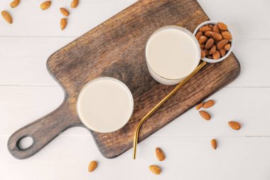 Hafif arka planda bir bardak lezzetli badem sütü.