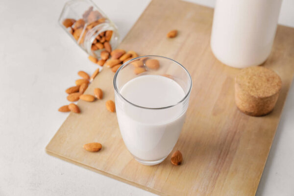 Стакан вкусного миндального молока на светлом фоне