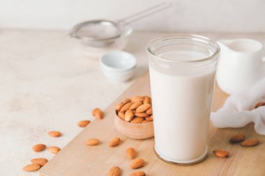 Hafif arka planda bir bardak lezzetli badem sütü.