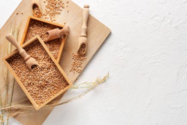 Tahta zemin üzerinde buğday taneleri olan kutular ve kepçeler