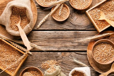 Tahta zemin üzerinde buğday taneleri olan çanak ve çanaklardan yapılmış çerçeve